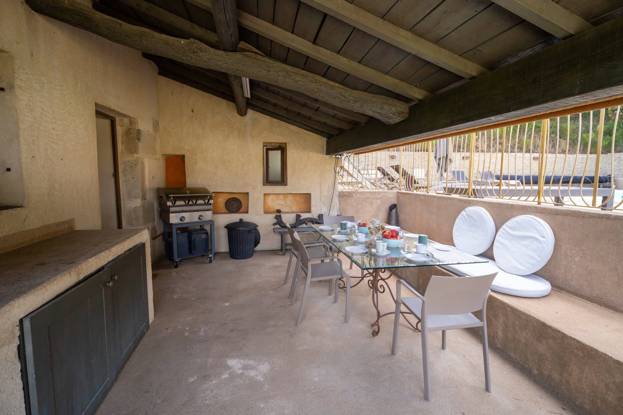 Terrasse couverte avec four à bois et table dressée